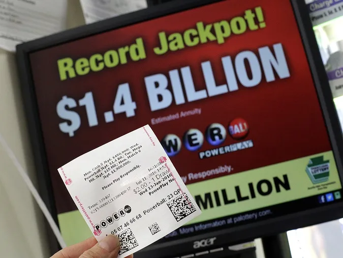 A Powerball ticket purchased in a convenience store in Lancaster, Pa., is held in front of a Pennsylvania Lottery computer screen Monday, Jan. 11, 2016. The Powerball jackpot has grown to over 1 billion dollars. (AP Photo/Gene J. Puskar)