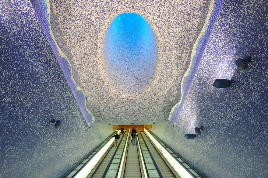 People walk in the "Cathedral" with the Crater of Luz by artist Oscar Tusquet Blanca in the Toledo subway station as part of the "Art Station Line 1" project on November 5, 2012 in Naples. AFP PHOTO / MARIO LAPORTA