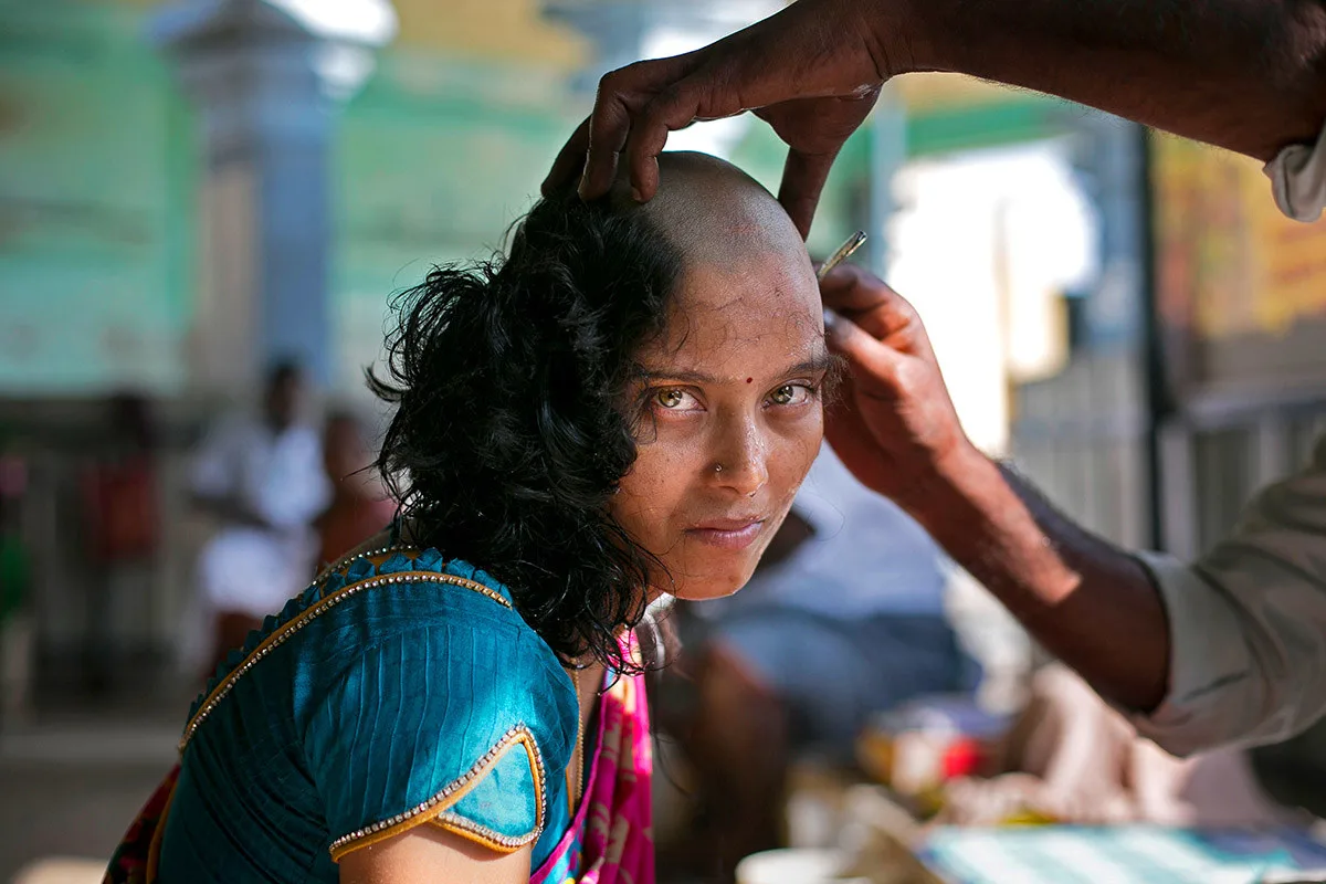 Rupa, 28, mencukur rambut di Kuil Murugan Tiruttani dengan harapan bahawa menderma kepada tuhan-tuhan akan menyembuhkan penyakit anaknya itu. Ia adalah perkara biasa bagi orang yang Hindu untuk mencukur kepala rambut mereka di sebuah kuil - Allison Joyce / Getty Images