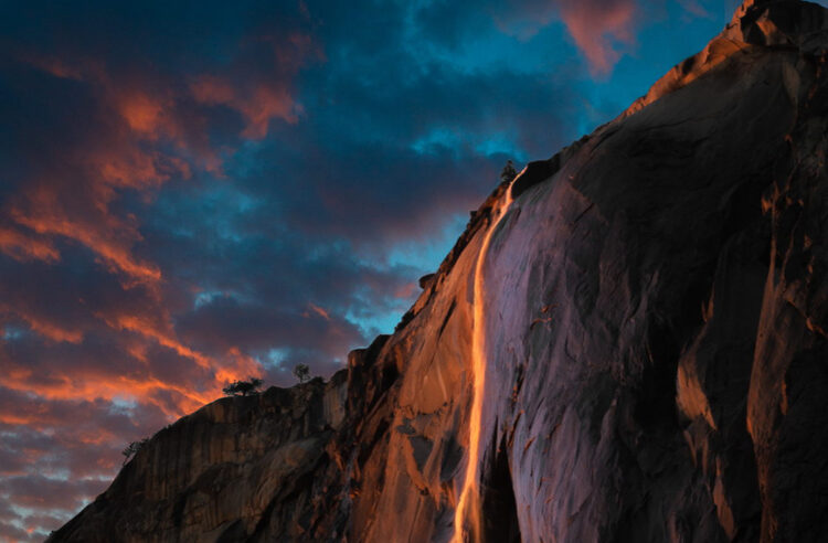 Cold days in the middle of Winter doesn’t always draw a lot of people to Yosemite Valley. The one exception is a short lived phenomenon in which the shadow of El Capitan sweeps across the face of the cliffs to align perfectly with Horsetail Fall causing the waterfall to glow in the dazzling colors of the setting sun. The effect gives the impression of falling lava or fire reminiscent of Yosemite’s famous Firefall where hot glowing embers were pushed off the cliffs of Glacier Point creating literally falling fire that could be seen from the valley floor. The Firefall event was discontinued in 1968 by the National Park Service in part due to huge crowds it drew and that it was not a naturally occurring event. But sometimes nature is more clever than we think and had been having its own version of Firefall each February for thousands of years but it wasn’t really noticed until 1973 when photographer Galen Rowell snapped his now famous photograph of Horsetail Fall glowing in the evening sun. Since that time each February photographers and nature lovers have been flocking to Yosemite to witness the natural version. The event has become so popular that the National Park Service now sections of areas to accommodate special parking. As is often the case with nature, the show varies from day to day and year to year and even minute to minute. Weather can make or break the event and as often is the case it may not occur at all. Clouds cause many to give up early and head down the long road for home only to have the sun pop out at the last minute creating fantastic light that lasts just a few minutes and then is gone. Drought in California made this year very questionable but a bit of snow and a last minute rainstorm caused the fall to spring to life. If you arrive early Horsetail Fall may be barely flowing but as the sun warms the High Sierra, the snow melts and the waterfall's flow picks up. So be sure to stick it out to the last minute. Thi