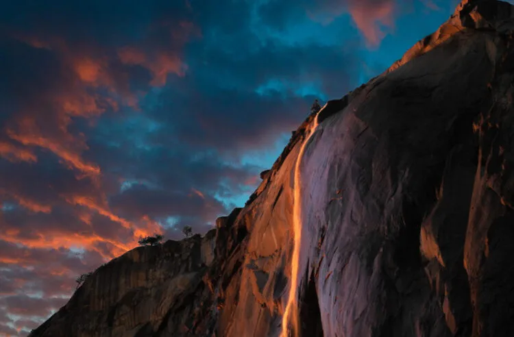 Cold days in the middle of Winter doesn’t always draw a lot of people to Yosemite Valley. The one exception is a short lived phenomenon in which the shadow of El Capitan sweeps across the face of the cliffs to align perfectly with Horsetail Fall causing the waterfall to glow in the dazzling colors of the setting sun. The effect gives the impression of falling lava or fire reminiscent of Yosemite’s famous Firefall where hot glowing embers were pushed off the cliffs of Glacier Point creating literally falling fire that could be seen from the valley floor. The Firefall event was discontinued in 1968 by the National Park Service in part due to huge crowds it drew and that it was not a naturally occurring event. But sometimes nature is more clever than we think and had been having its own version of Firefall each February for thousands of years but it wasn’t really noticed until 1973 when photographer Galen Rowell snapped his now famous photograph of Horsetail Fall glowing in the evening sun. Since that time each February photographers and nature lovers have been flocking to Yosemite to witness the natural version. The event has become so popular that the National Park Service now sections of areas to accommodate special parking. As is often the case with nature, the show varies from day to day and year to year and even minute to minute. Weather can make or break the event and as often is the case it may not occur at all. Clouds cause many to give up early and head down the long road for home only to have the sun pop out at the last minute creating fantastic light that lasts just a few minutes and then is gone. Drought in California made this year very questionable but a bit of snow and a last minute rainstorm caused the fall to spring to life. If you arrive early Horsetail Fall may be barely flowing but as the sun warms the High Sierra, the snow melts and the waterfall's flow picks up. So be sure to stick it out to the last minute. Thi