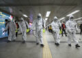 Workers wearing protective gears disinfect as a precaution against the new coronavirus at the subway station in Seoul, South Korea, Wednesday, March 11, 2020. (Kim Sun-woong/Newsis via AP)
