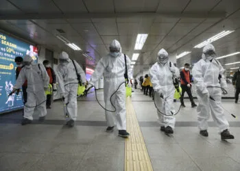 Workers wearing protective gears disinfect as a precaution against the new coronavirus at the subway station in Seoul, South Korea, Wednesday, March 11, 2020. (Kim Sun-woong/Newsis via AP)