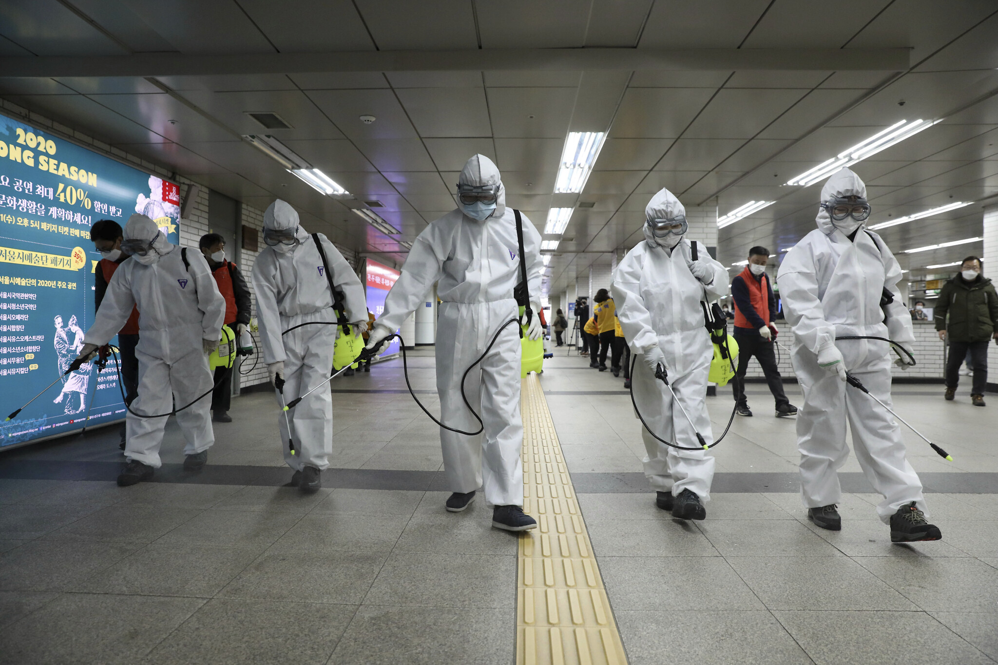 Workers wearing protective gears disinfect as a precaution against the new coronavirus at the subway station in Seoul, South Korea, Wednesday, March 11, 2020. (Kim Sun-woong/Newsis via AP)