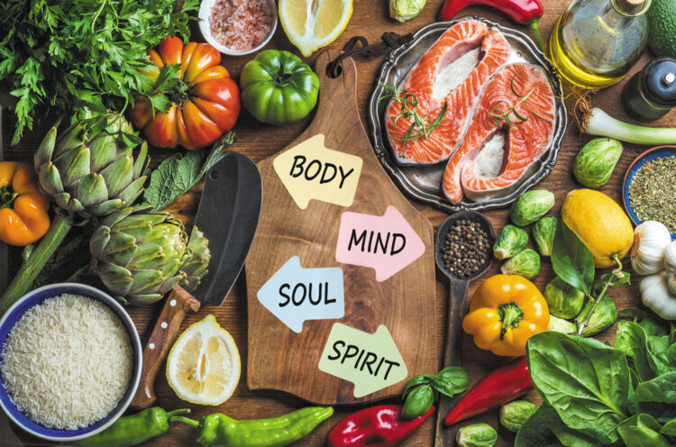 Dinner cooking ingredints. Raw uncooked salmon fish with vegetables, rice, herbs and spices over rustic wooden background, top view, copy space. Chopping board in center