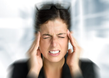 Businesswoman with intense stress and painful headache. Woman in job problems.