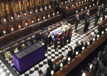 Britain's Queen Elizabeth watches as pallbearers carry the coffin of the Duke of Edinburgh during his funeral at St George's Chapel in Windsor Castle, Windsor, England, Saturday April 17, 2021. Prince Philip died April 9 at the age of 99 after 73 years of marriage to Britain's Queen Elizabeth II. (Dominic Lipinski/Pool via AP)