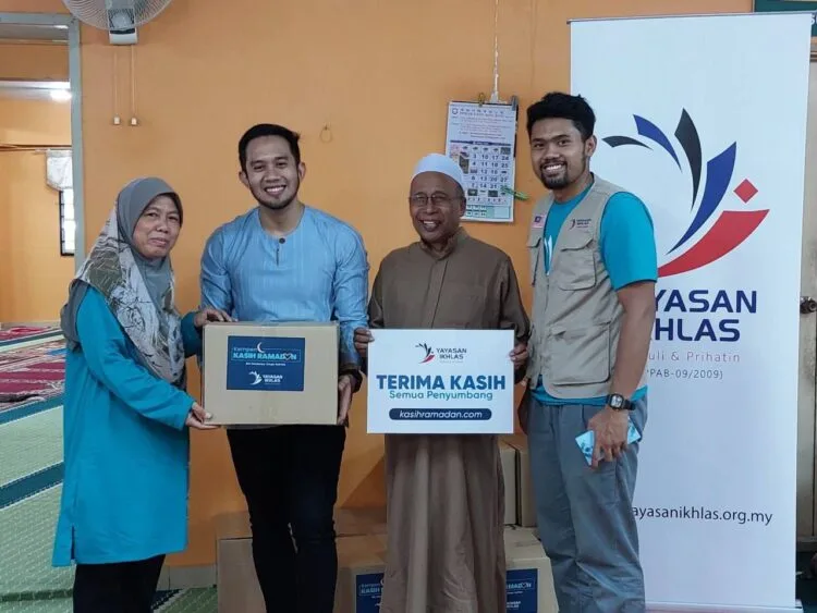 FIzi Ali bersama Eksekutif Kanan Operasi Yayasan Ikhlas Bangi, Muhammad Afifuddin Ramli (paling kanan) menyerahkan sumbangan kepada wakil asnaf